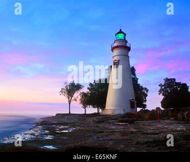 Il Marblehead faro che irradia la luce verde come il sole riscalda il cielo orientale a Marblehead Ohio sul Lago Erie, STATI UNITI D'AMERICA Foto Stock