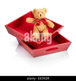 Orsacchiotto di peluche con un fiocco rosso in scatole di giocattoli Foto Stock
