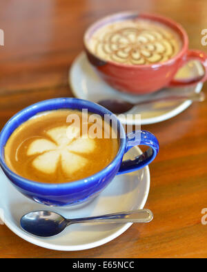 Tazze di caffè con latte su un tavolo di legno. Foto Stock
