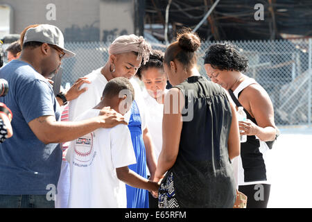 Ferguson, Mo., noi. Il 15 agosto, 2014. La gente a pregare nel luogo del distrutto viaggio veloce dopo il capo di polizia Thomas Jackson rilascio del nome del funzionario che shot Michael Brown. Credito: Gino's immagini Premium/Alamy Live News Foto Stock