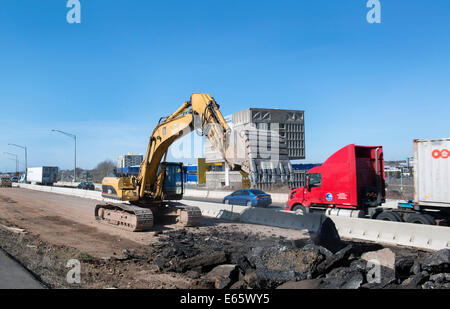 Escavatore lavorando sulla I-95 New Haven porto il progetto Crossing la lacerazione di vecchie autostrada per farne uno nuovo. Foto Stock