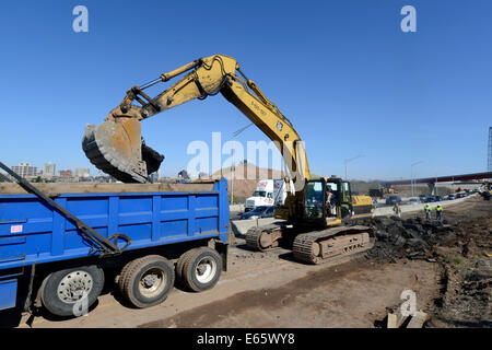 Escavatore lavorando sulla I-95 New Haven porto il progetto Crossing la lacerazione di vecchie highway e caricarla in un autocarro con cassone ribaltabile per fare il modo Foto Stock