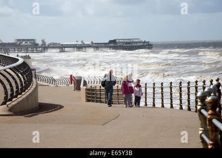 North Pier di Blackpool e un mare mosso i turisti sulla prom in agosto condizioni meteorologiche ventose Foto Stock