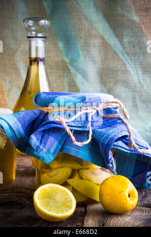 Vaso di frutta mela cotogna e liquore di mela cotogna su un tavolo di legno Foto Stock