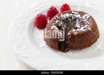 Torta di lava e lamponi freschi e una spolverata di zucchero a velo. Foto Stock