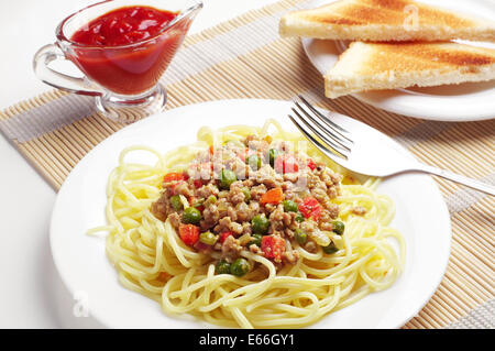 Spaghetti con le carni macinate e le verdure sul tavolo Foto Stock