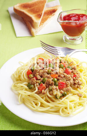 Spaghetti con carne e verdure sulla tovaglia verde Foto Stock