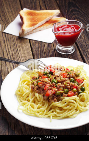 Spaghetti con carne macinata e verdure su vintage tavolo in legno Foto Stock