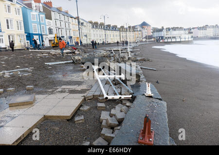 Aberystwyth, Wales, Regno Unito. 03 gennaio 2014. 8-prima: Promenade e ringhiere in mare durante una tempesta. Pulizia dopo la peggior tempesta a colpire Aberystwyth in memoria viva. Ampie parti del lungomare e ringhiere in mare sono stati strappati via durante la violenta tempesta questa mattina. Autorità locale lavoratori stima che il costo della chiarezza e per le riparazioni si; eseguire in diverse centinaia di migliaia di sterline. 5. 6m alto springtide e gale force south westerly venti portate massive tesse pounding contro il lungomare e il porto a Aberystwyth sulla West Wales coast. © keith morris/Alamy caratteristiche Foto Stock