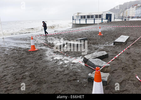 Aberystwyth, Wales, Regno Unito. 03 gennaio 2014. 14-prima:PROMENADE durante le tempeste invernali. Pulizia dopo la peggior tempesta a colpire Aberystwyth in memoria viva. Ampie parti del lungomare e ringhiere in mare sono stati strappati via durante la violenta tempesta questa mattina. Autorità locale lavoratori stima che il costo della chiarezza e per le riparazioni si; eseguire in diverse centinaia di migliaia di sterline. 5. 6m alto springtide e gale force south westerly venti portate massive tesse pounding contro il lungomare e il porto a Aberystwyth sulla West Wales coast. © keith morris/Alamy caratteristiche Foto Stock