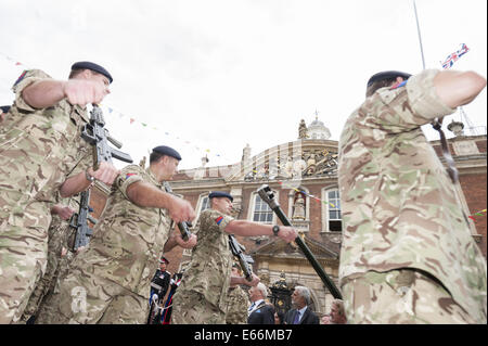 Worcester, Worcestershire, Regno Unito. 16 Ago, 2014. La Prima Guerra Mondiale e armi contemporaneo ha dato il saluto a Worcester Racecourse come uno dei punti salienti dell'Artiglieria giorno speciale, che segna il centocinquantesimo anniversario della città esercito locale unità di riserva, 214 (Worcestershire) Batteria Royal Artillery e il centenario della Grande Guerra. Nella foto: soldati passano Worcester's historic Guildhall in High Street come parte della città è giorno di artiglieria celebrazioni. © Lee Thomas/ZUMA filo/Alamy Live News Foto Stock