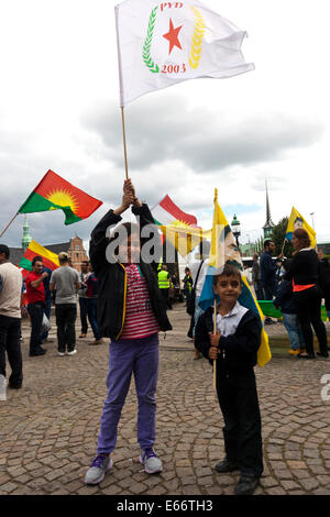 Copenaghen, Danimarca - Agosto 16th, 2014: Curdi dimostra di fronte al parlamento Danese di Copenaghen contro ISIS (Stato islamico) la guerriglia e le atrocità commesse in Iraq. La foto di una ragazza tiene la bandiera di PYD (Unione Democratica partito) dal nord della Siria. PYD è affiliato con il PKK. Credito: OJPHOTOS/Alamy Live News Foto Stock