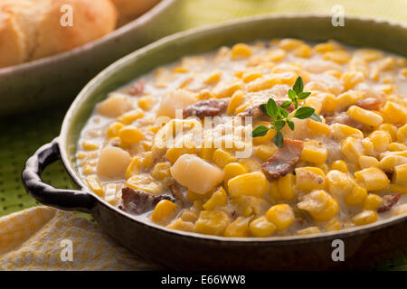 Una ciotola di fatti in casa zuppa di mais con pancetta, patate, formaggi e biscotti. Foto Stock