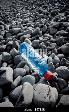 Una bottiglia di plastica gettati su una spiaggia ghiaiosa Foto Stock