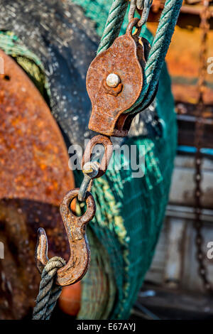 Sistema di carrucole a gancio arrugginite e reti da pesca su barca da pesca commerciale a Eden Harbour, Eden, Costa Sud del NSW, Australia Foto Stock