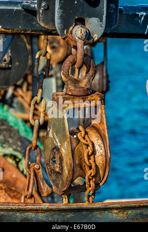 Close up di rusty pulegge delle catene e sulla barca da pesca nel porto di Eden, Eden costa sud del NSW, Australia Foto Stock