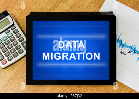La migrazione dei dati parola sulla tavoletta digitale con la calcolatrice e grafico finanziario Foto Stock