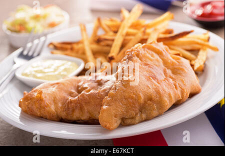Un piatto di squisiti piatti a base di pesce e patatine con salsa tartara e coleslaw. Foto Stock