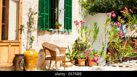 Tradizionale cortile con sedie e un sacco di fiori o nel vecchio borgo, sull'isola di Mallorca, Spagna Foto Stock