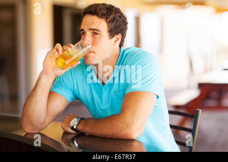 Considerato giovane uomo di bere birra presso il bar Foto Stock