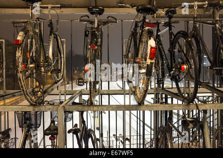 Parcheggio bici oltre le linee ferroviarie coperte di neve ad Aarhus in Danimarca, Europa Foto Stock