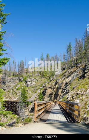 Mountain bike Escursioni in bicicletta in sella alla vecchia ferrovia in legno tralicci trail in Myra Canyon, Kelowna, British Columbia, Canada. Foto Stock