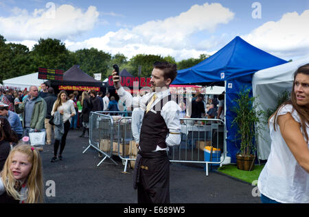 Battersea Park, Food Festival. Londra REGNO UNITO. 17 agosto 2014 cameriere tentativi per ottenere un segnale per la sua connessione wi-fi a pagamento macchina. Foto Stock