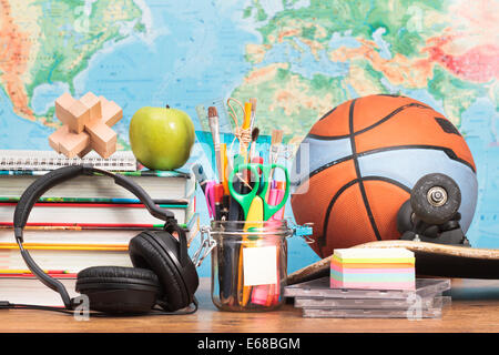 Accessori per la scuola su desktop con mappa in background Foto Stock