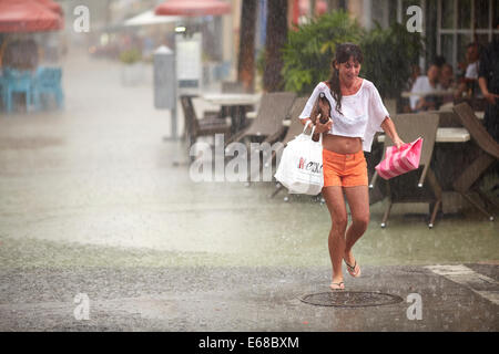 Donna Shopping trasporto catturati fuori da Miami tempesta tropicale Foto Stock