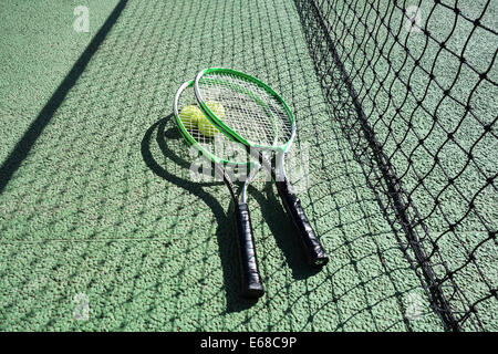 Campo da tennis, racchette e palline da tennis su un campo da tennis che mostra net. Campo da tennis Foto Stock