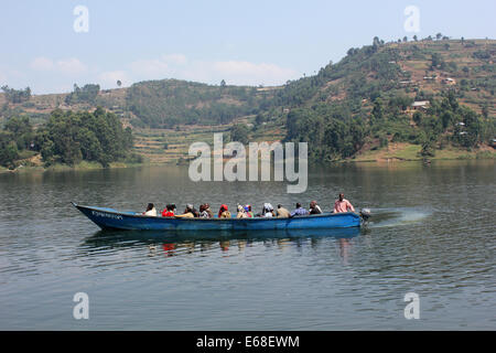 Passeggeri viaggiano su una canoa sul lago Bunyonyi e in Uganda occidentale. Foto Stock