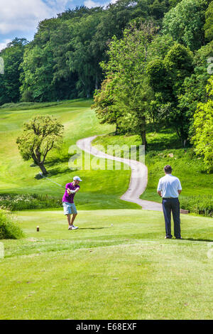 Il Golfer rinvio fuori mentre un altro orologi. Foto Stock