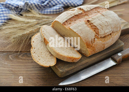 Fette di pane sul tagliere closeup su sfondo di legno Foto Stock