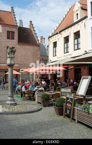 I turisti si prendono una pausa in un ristorante Huidenvettersplein (i conciatori Square) , Bruges, Belgio Foto Stock