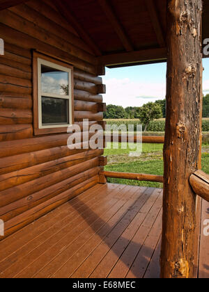 Log Cabin con vista di un campo di mais Foto Stock