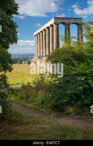 I turisti al di sotto della incompiuta Monumento Nazionale su Calton Hill, Edimburgo, Lothian, Scozia Foto Stock