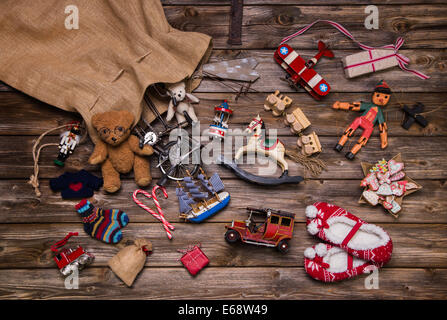 Memorie di Natale nell'infanzia: il vecchio usato e giocattoli su sfondo di legno per i regali. Foto Stock