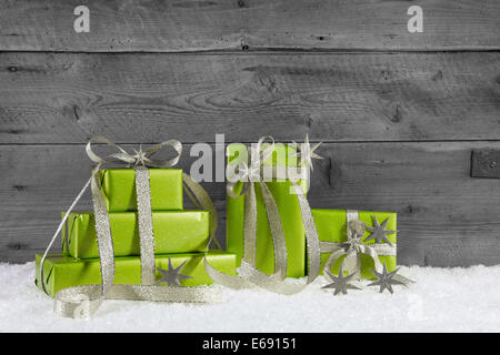 Verde scatole regalo per Natale su grigio shabby chic sfondo. Foto Stock