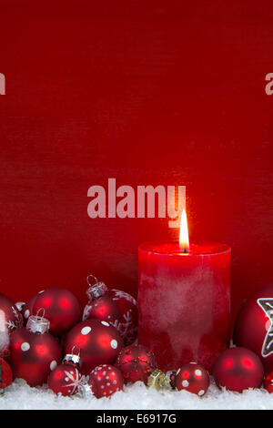 Red christmas candle con sfere su sfondo di legno. Foto Stock