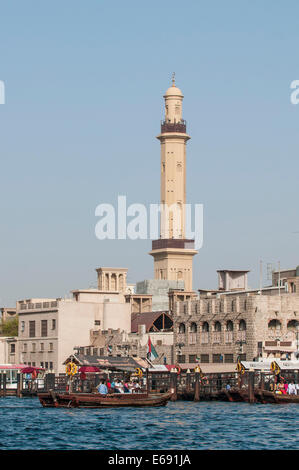 Un minareto della moschea persone torri a cavallo di un acqua abra taxi a Bur Dubai Creek Al Hamriya District, Dubai, Emirati Arabi Uniti EMIRATI ARABI UNITI. Foto Stock