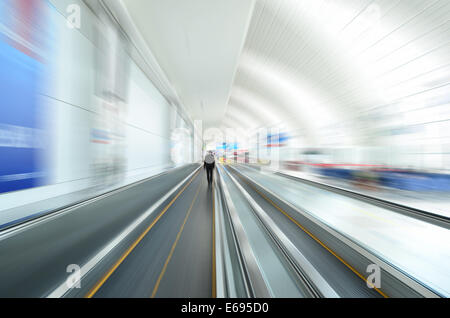 Il movimento di un viaggiatore in Escalator di un aeroporto Foto Stock