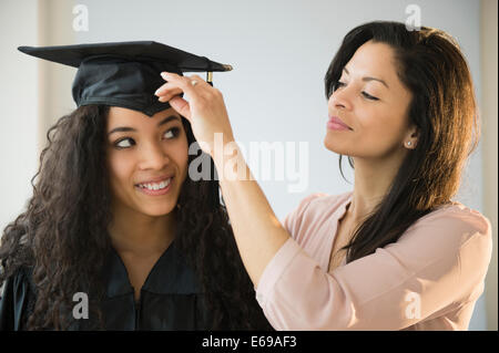 Regolazione madre figlia adolescente del cappuccio di graduazione Foto Stock