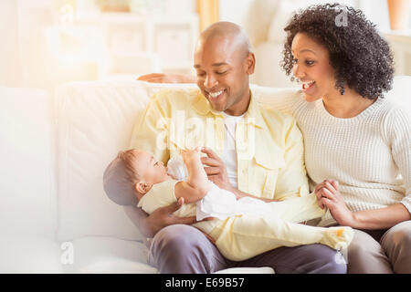 I genitori del bambino di alimentazione sul divano Foto Stock