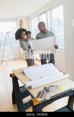 Famiglia esaminando blueprint nella nuova casa Foto Stock