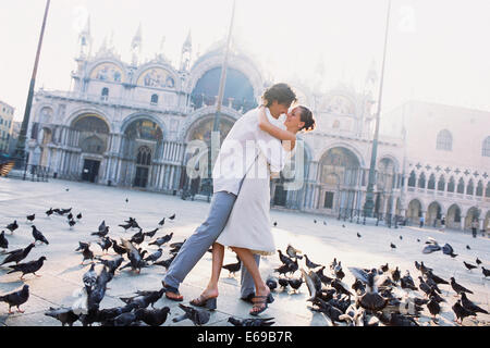 Coppia circondata da piccioni in Piazza San Marco, Venezia, Veneto, Italia Foto Stock