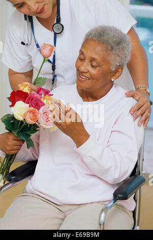 Senior paziente ottenere fiori in ospedale Foto Stock