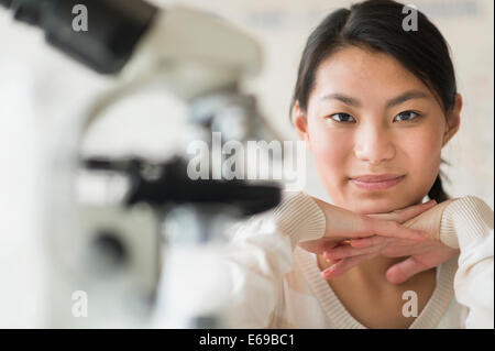 Razza mista ragazza sorridente nel laboratorio di scienze Foto Stock