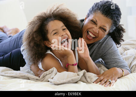 Donna Senior e nipote di ridere sul letto Foto Stock