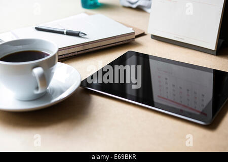 Tablet PC sul tavolo con libro e caffè Foto Stock