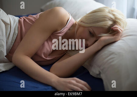 La donna caucasica la posa a letto Foto Stock